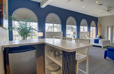 2 Queen Bed Suite at Alister Square Inn with bright decor, arched windows, and blue accents